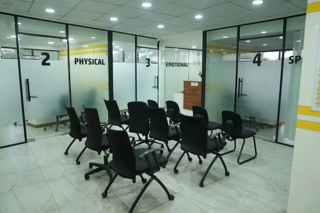 Modern reception and waiting area at Sharvari Hospital featuring comfortable seating and glass-partitioned consultation rooms.